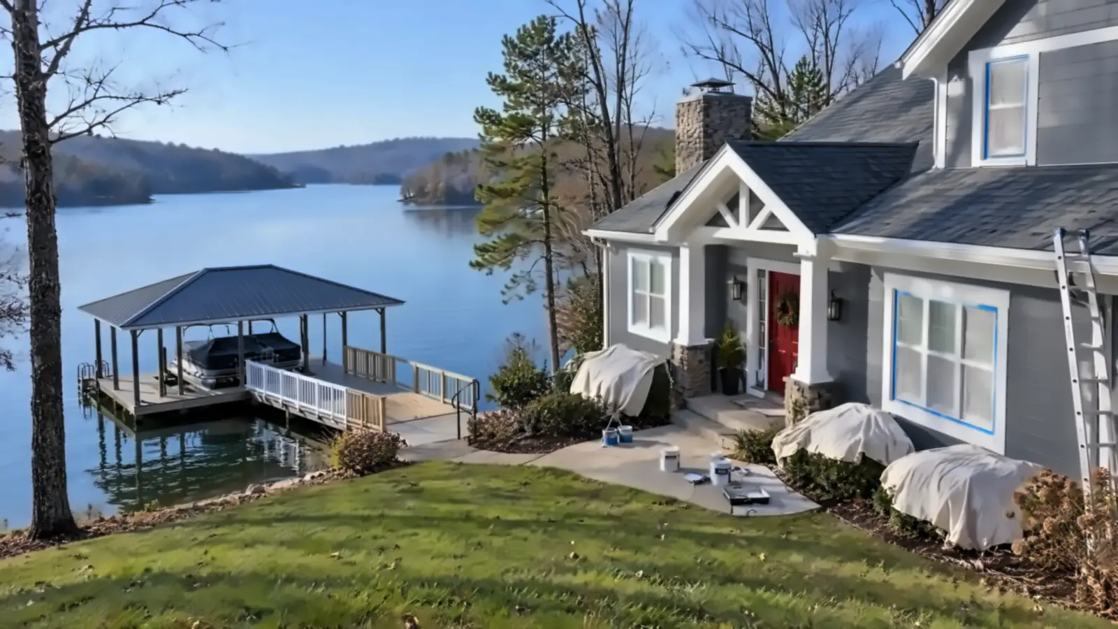 Gray lake home with white trim above a covered boat dock on Watts Bar Lake, painters in Kingston, TN by Castle Painters